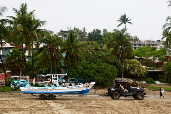 A fisherman moves his boat before the arrival of Hurricane Erick in Puerto Escondido, Oaxaca state, Mexico, Wednesday, June 18, 2025. (AP Photo/Luis Alberto Cruz)