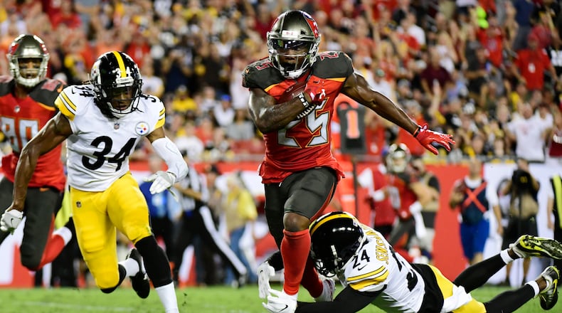 Peyton Barber #25 of the Tampa Bay Buccaneers runs for 18 yards to set up a touchdown in the firs quarter against the Pittsburgh Steelers on September 24, 2018 at Raymond James Stadium in Tampa, Florida.