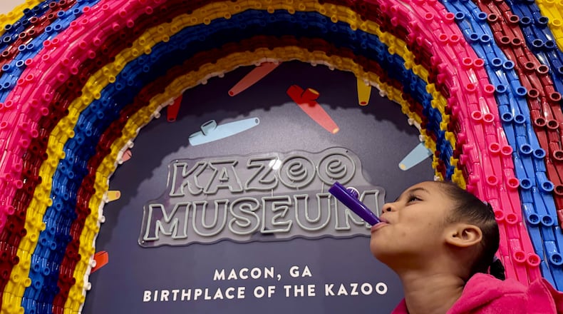 At a kazoo exhibit inside Macon, Georgia’s Tubman African American Museum, museum visitor Leilei Jones, 7, hums on a kazoo. (Joe Kovac Jr. / AJC)