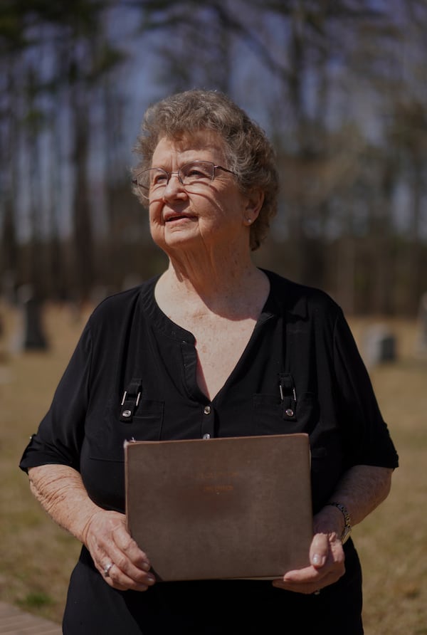 Reba Dell Windom, a longtime Sacred Harp singer poses for a portrait with her worn 1991 edition at Holly Springs Primitive Baptist Church in Bremen, Ga., on Sunday, March 23, 2025. (AP Photo/Jessie Wardarski)