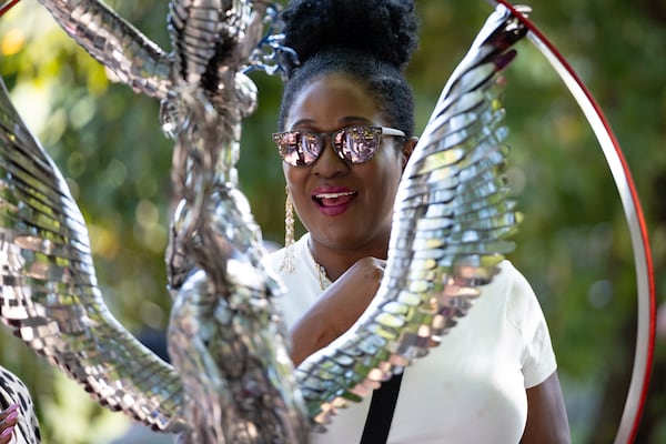 Gabrielle McMahan checks out the sculpture “Celestial Fury” by Eric Shupe at the Atlanta Dogwood Festival at Piedmont Park on Saturday, April 11, 2026. Schupe’s sculptures are made from forks and spoons. (Ben Gray for the AJC)