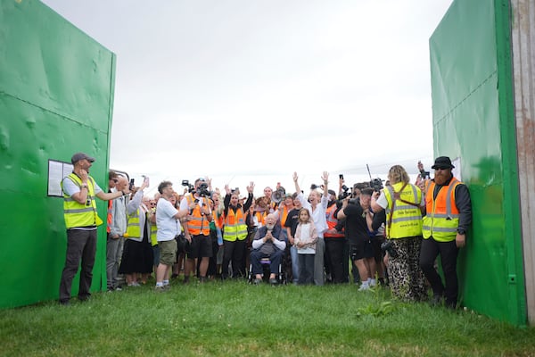 Emily Eavis, center right, and Michael Eavis, center, react with others as the gates open, on the first day of the Glastonbury Festival at Worthy Farm, in Somerset. England, Wednesday June 25, 2025. (Yui Mok/PA via AP)