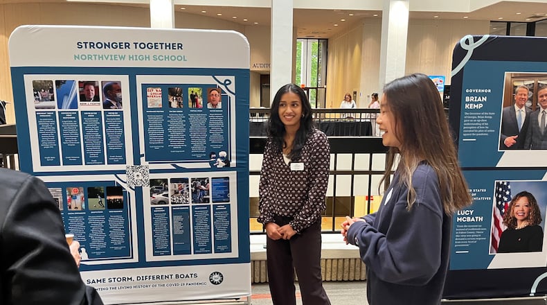 Northview High students Riya Havanur (center) and Irene Huang showcase the work they did with Student Leadership Johns Creek to document the pandemic's impact.