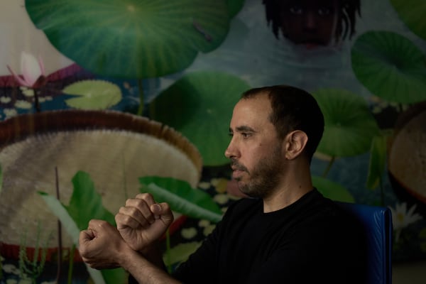 Freed Israeli hostage Tal Shoham, who was held by Hamas militants in the Gaza Strip, demonstrates how his captors handcuffed him, in Tel Aviv, Israel, Tuesday, April 22, 2025. (AP Photo/Maya Alleruzzo)