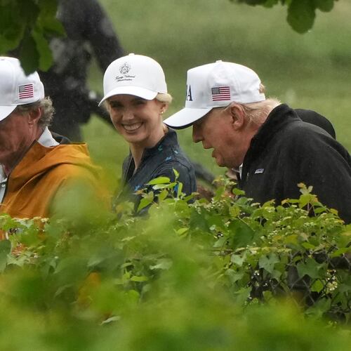 Interior Secretary Doug Burgum (left), White House aide Natalie Harp and President Donald Trump walk during a tour of the East Potomac Park golf course in June. (Mark Schiefelbein/AP)