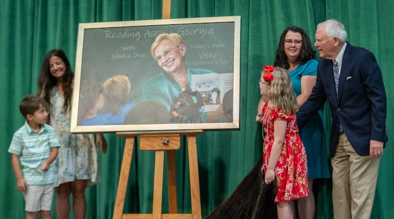 Former Gov. Nathan Deal, right, unveils a portrait of his late wife Sandra Deal with the help of teachers and students at the school named for her. Family, friends and community members gather for the dedication ceremony of Sandra Dunagan Deal Elementary School. Monday, August 26, 2024 (Ben Hendren for the Atlanta Journal-Constituion)