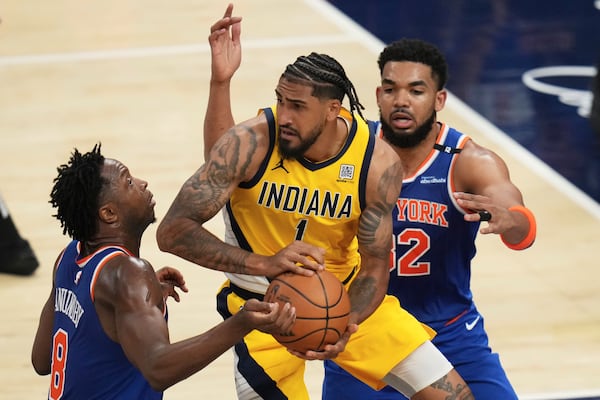 Indiana Pacers forward Obi Toppin (1) looks to pass the ball between New York Knicks forward OG Anunoby, left, and center Karl-Anthony Towns during the second half of Game 3 of the Eastern Conference finals of the NBA basketball playoffs Sunday, May 25, 2025, in Indianapolis. (AP Photo/Jeff Roberson)