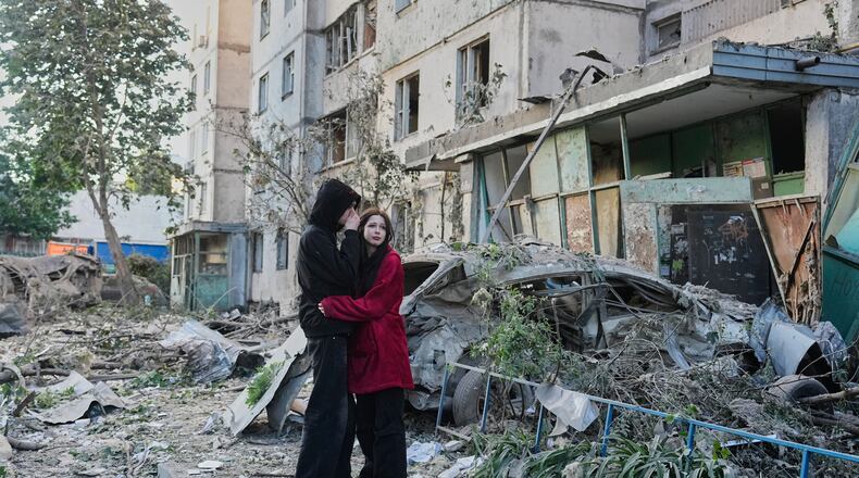 People react as they look at the site of Russian missile strike that hit a residential building in Kyiv, Ukraine, Tuesday, June 2, 2026. (AP Photo/Efrem Lukatsky)