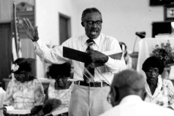 In this photo provided by the State Archives of Florida, M.L. Long leads sacred harp singers at the S.E. Alabama & Florida Union Sacred Harp Sing in Campbellton, Fla., on Nov. 24, 1980. (Peggy A. Bulger/State Archives of Florida via AP)