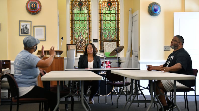 Anita DeMyers (center), the executive director at Trinity Community Ministries, discusses with Felicia Jones (left), receptionist, and Clyde "Ali" Wilson, a case manger. During the COVID-19 pandemic, Trinity Community Ministries has continued to care for men, experiencing homelessness, addiction and mental health disabilities. (Hyosub Shin / Hyosub.Shin@ajc.com)