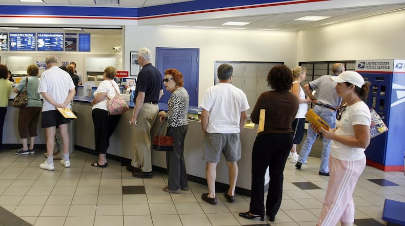 ROSWELL, GA — The first-class mail postage rate increased to 41 cents on July 5, 2014. The stamp machine was sold out of the new stamps and the morning line was long at the Roswell post office on Alpharetta Highway in Roswell. (BOB ANDRES / AJC staff)
