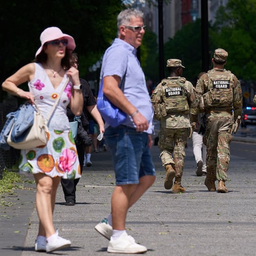 Members of the Florida National Guard pass by tourists on a sidewalk Friday April 17, 2026, in Washington. (AP Photo/Jacquelyn Martin)