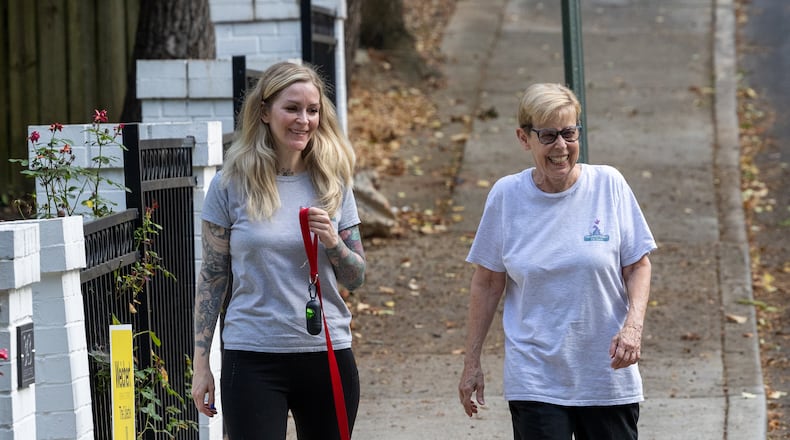 Beverly Means (left) and volunteer Lois Gross walk a dog for a client in Decatur, one of the many services provided by Transitions Pet Care. (Phil Skinner for the AJC)
