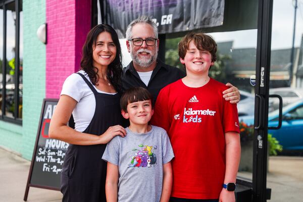 Owners Chris and Tiffany Brennaman with their sons Alex (left) and Erik at Infinite Horizons Arcade. (Abbey Cutrer/AJC)