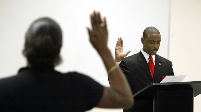 January 1, 2005: On his first official day as Clayton sheriff, Hill fired 27 officers and had them escorted from the building with snipers posted on the roof. In this photo, Hill swears in corrections officers at the Clayton County Sheriff's Department.