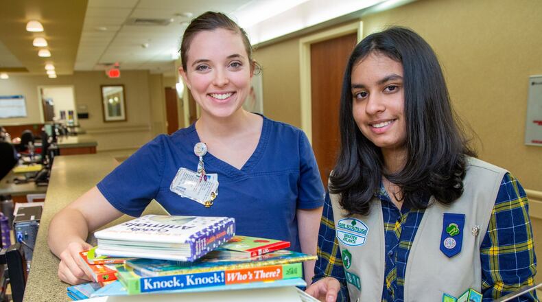 Anoushka Talwar (right) goes through some of the books she put in a library for parents of preemies with NICU nurse Gabrielle John at Emory Johns Creek Hospital. She created libraries at two metro Atlanta hospitals NICUs as a Girl Scout project. She has a passion for preemies, both she and her brother weighed in under three pounds. (Photo by Phil Skinner)
