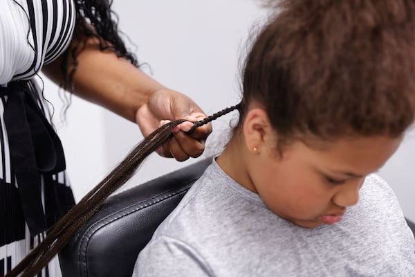 Layla Brown gets her hair braided at Lux Studio Salon Suites on Monday, Aug. 4, 2025. Foster mother Lisa Callahan drove them from Bartow County because, she said, it's hard to find quality care for Black hair there. (Natrice Miller/AJC)