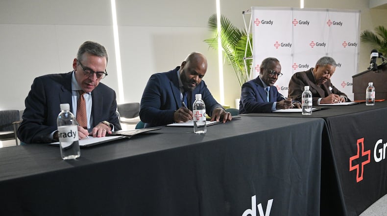 Officials from Grady, Fulton and DeKalb counties (from left) John Haupert, president and CEO of Grady Health System, Jevon Gibson, CEO of The Fulton-DeKalb Hospital Authority, Mike Thurmond, CEO of DeKalb County, and Robb Pitts, Chairman of the Fulton County Board of Commissioners, sign documents during a press conference to announce and sign a new deal to subsidize the hospital for indigent medical care at Grady Memorial Hospital, Tuesday, December 9, 2024, in Atlanta. (Hyosub Shin / Hyosub.Shin@ajc.com)