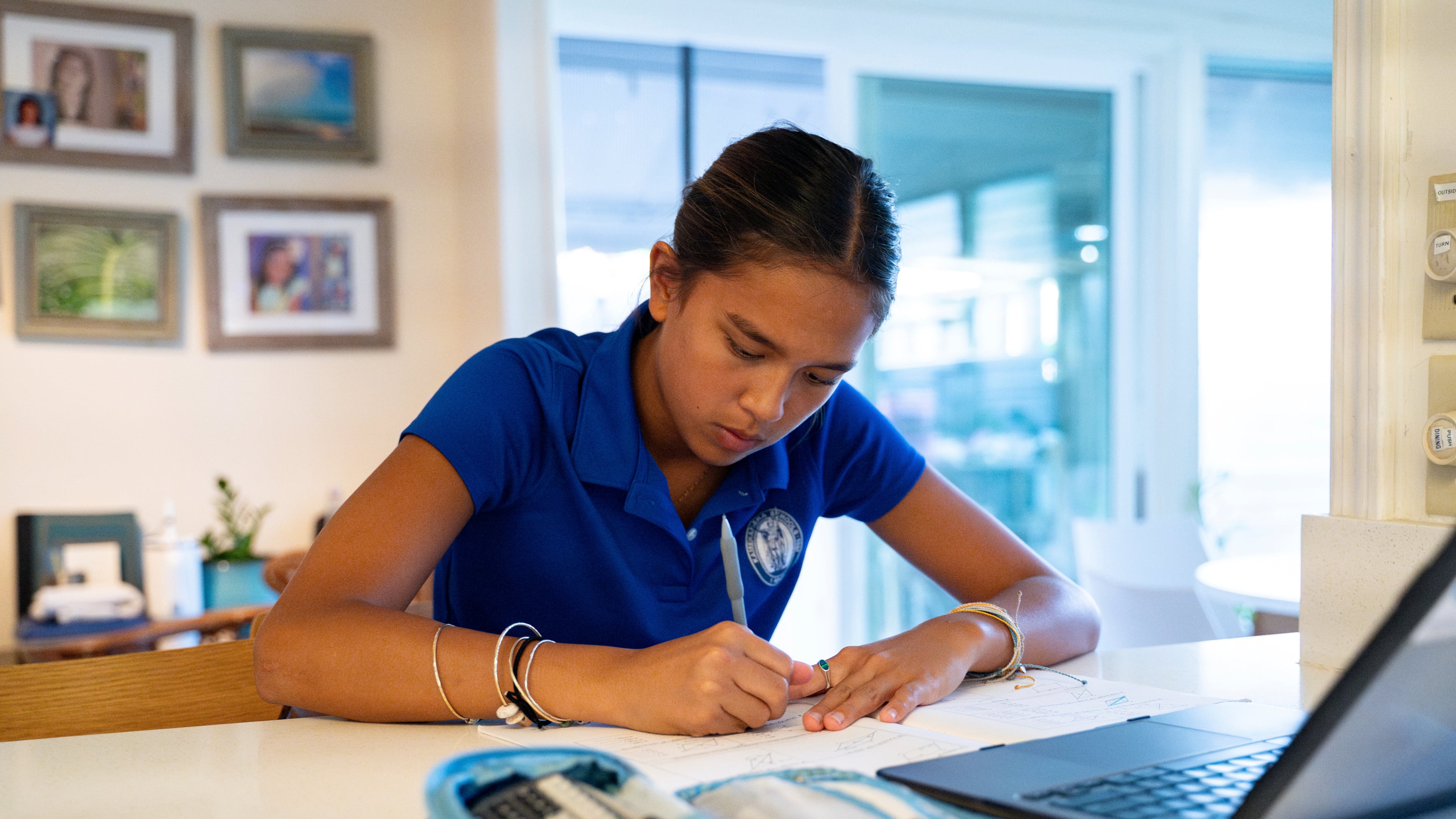 Kapua Ong does math homework at her home in Honolulu, on Thursday, Sept. 11, 2025. (AP Photo/Mengshin Lin)
