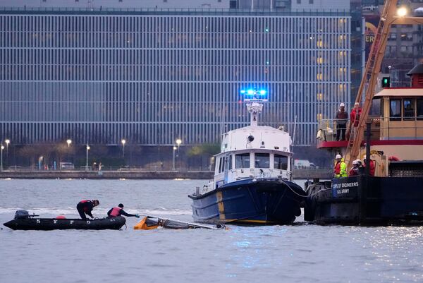 Divers investigate the scene where a helicopter crashed into the Hudson River, Thursday, April 10, 2025, in Jersey City, N.J. (AP Photo/Seth Wenig)