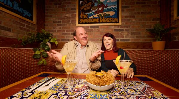 This undated photo provided by Chili's, shows actors Brian Baumgartner, left, who played Kevin Malone, and Kate Flannery, who played Meredith Palmer in the TV series "The Office," posing in a soon-to-be opened Chili's in Dickson City, Pa. (Ben Rosenzweig, Chili's via AP)