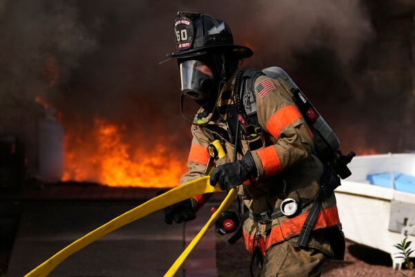 Firefighters battle a house fire Wednesday, April 23, 2025, in Lacey Township, N.J. (AP Photo/Matt Slocum)