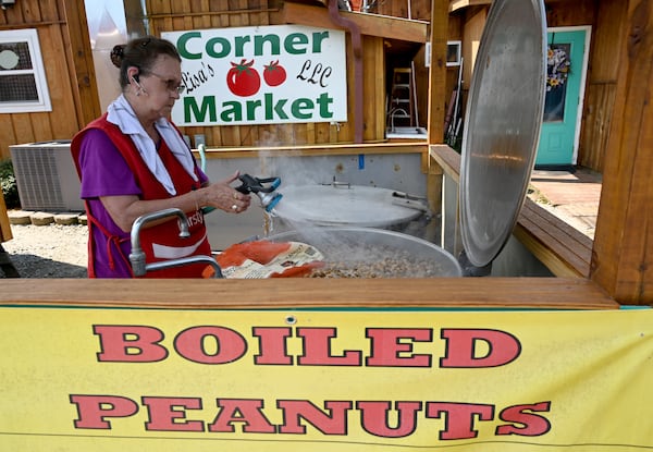 Loria Abanathy adds water into a steam kettle at one of Hardy Farms’ roadside boiled peanut stands in Hawkinsville. (Hyosub Shin/AJC)