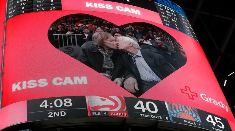 Former President Jimmy Carter kisses his wife, Rosalynn, during the first half of the game between the Hawks and the New York Knicks at State Farm Arena. (AP Photo/John Bazemore)