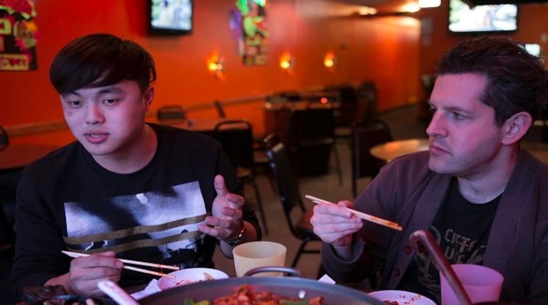 Deuki Hong and Matt Rodbard, authors of the cookbook "Koreatown," talk over dinner at Dancen in Chicago's Lincoln Square neighborhood. The authors ate a meal that featured seafood pancakes, spicy marinated chicken and kimchee fried rice. (Kristan Lieb/Chicago Tribune/TNS)