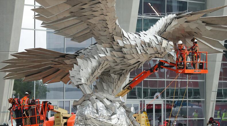 Workers install a 73,000-pound stainless steel sculpture of a falcon outside Mercedes-Benz stadium Thursday, April 27, 2017, in Atlanta.