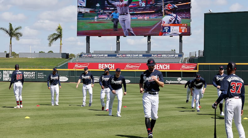 Braves first baseman Freddie Freeman is seen on the big screen rounding the bases on his home run during game six of the World Series while Dansby Swanson and the Braves loosen up in CoolToday Park during the first day of team practice at Spring Training on Monday, March 14, 2022, in North Port.   “Curtis Compton / Curtis.Compton@ajc.com”`
