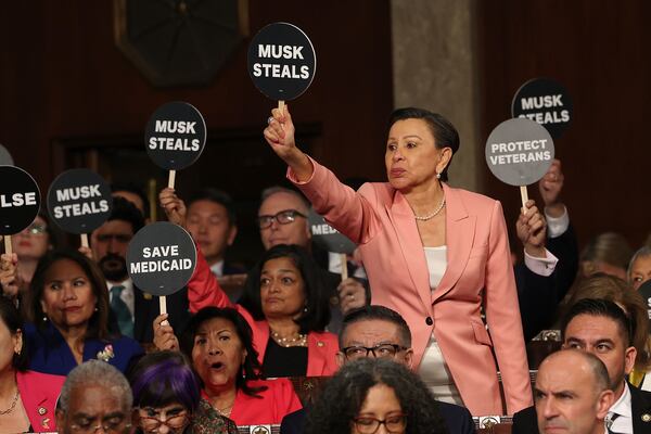 Democrats, including U.S. Rep. Nydia Velazquez, a Democrat from New York, held signs in protest as President Donald Trump addressed a joint session of Congress at the Capitol in Washington on Tuesday.