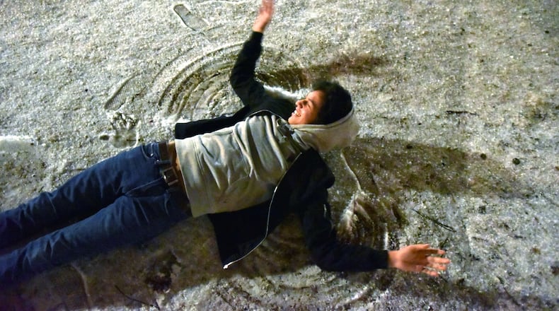 Mark Castillo plays as a wintry mix of sleet, rain and snow is falling in Suwanee Town Center Park Friday night, January 6, 2017. But a lot of Atlantans woke up Saturday to... no snow. None. They weren't thrilled.