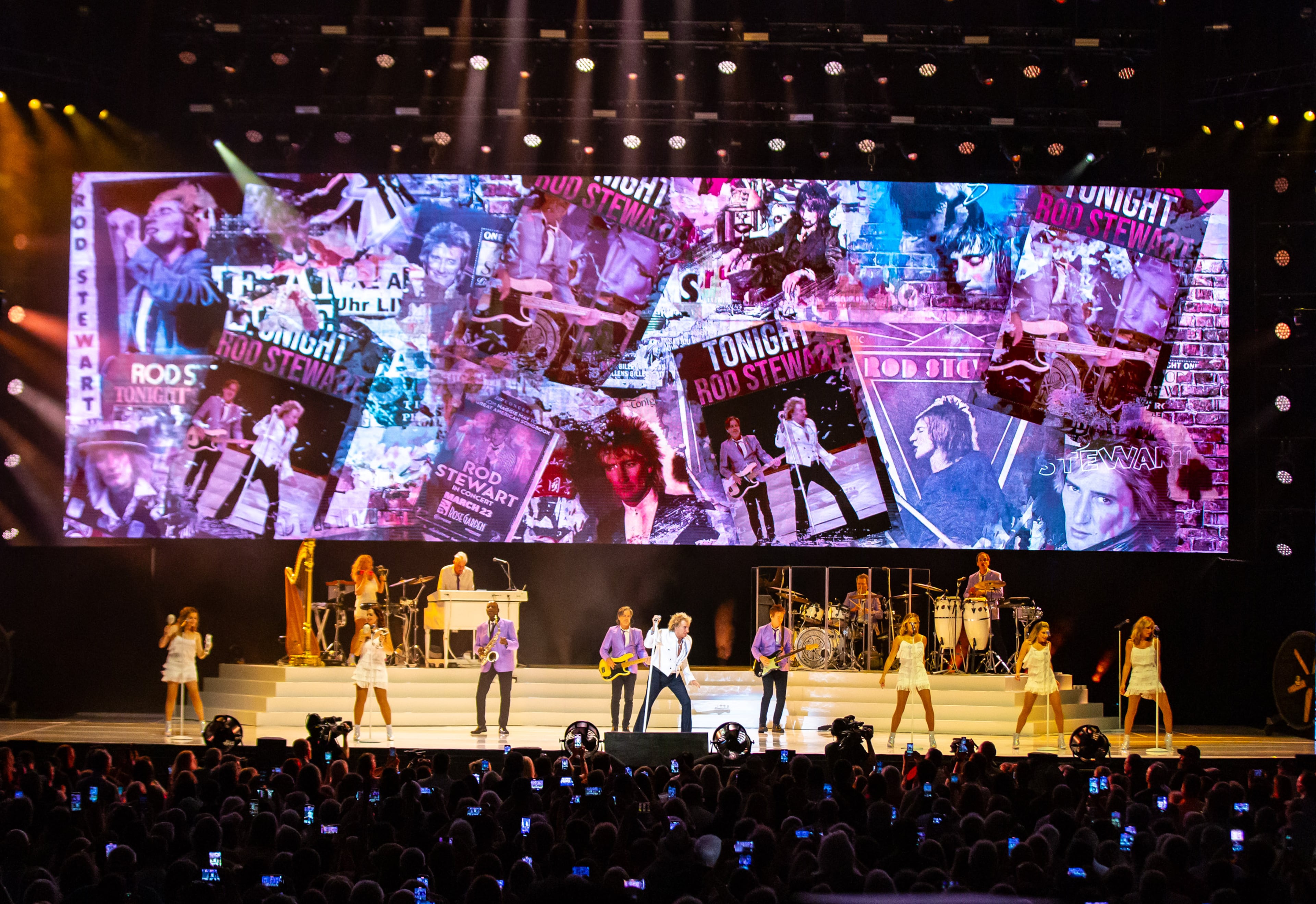 A few minutes before 9 p.m., Rod Stewart — with his spiky blonde hair and wearing a white suit jacket and black slacks — hit the stage. “It’s ridiculously hot, but we’re ready for you,” Stewart said. (Ryan Fleisher for the AJC)