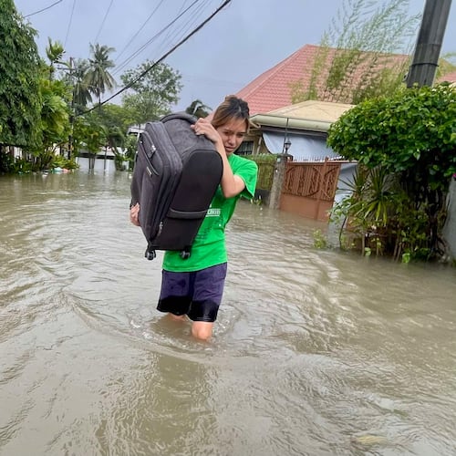 A resident navigates a flooded street as they evacuate to safer grounds as Typhoon Kalmaegi affects Cebu city, central Philippines, Tuesday Nov. 4, 2025. (AP Photo/Jacqueline Hernandez)
