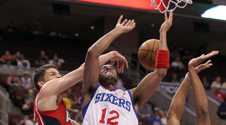 The Philadelphia 76ers' Evan Turner (12) has his shot blocked by the Atlanta Hawks' Kyle Korver, left, and Al Horford during the first quarter at the Wells Fargo Center in Philadelphia, Pennsylvania, on Wednesday, April 10, 2013. (Yong Kim/Philadelphia Daily News/MCT)