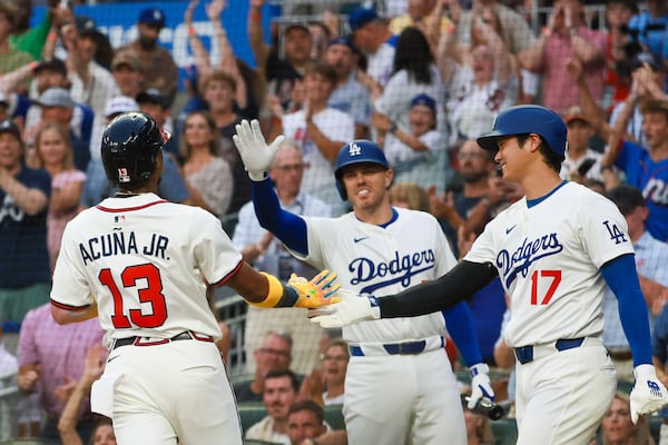 Former Brave Freddie Freeman (center) and Dodgers teammate Shohei Ohtani greeted Atlanta's Ronald Acuña Jr. after he scored in the first inning.
