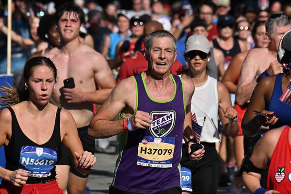 Runners cross the finish line during the 56th AJC Peachtree Road Race on Friday, July 4, 2025, in Atlanta. About 52,000 runners participated in the event. (Hyosub Shin/AJC)