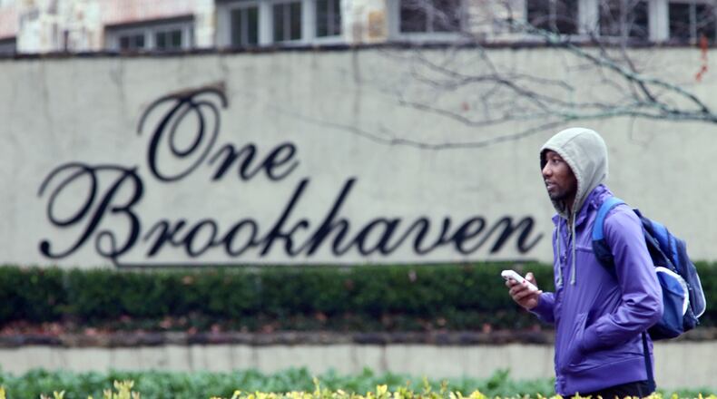Brenton Etuk walks pass a Brookhaven sign on Peachtree Rd. on his way to work in Buckhead. Brookhaven on Monday, December 17, 2012, officially became DeKalb County’s largest and Georgia’s newest city.