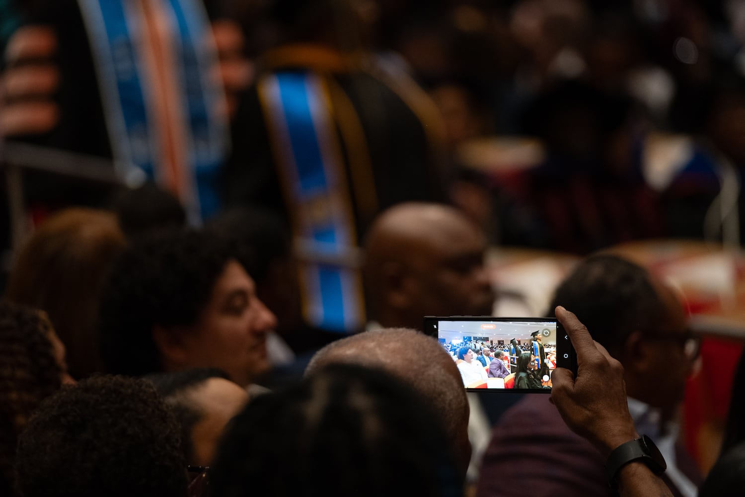 A person records a video as students move into the graduation ceremony for Morehouse School of Medicine on Saturday, May 16, 2026, in Atlanta. (Ben Gray for the AJC)