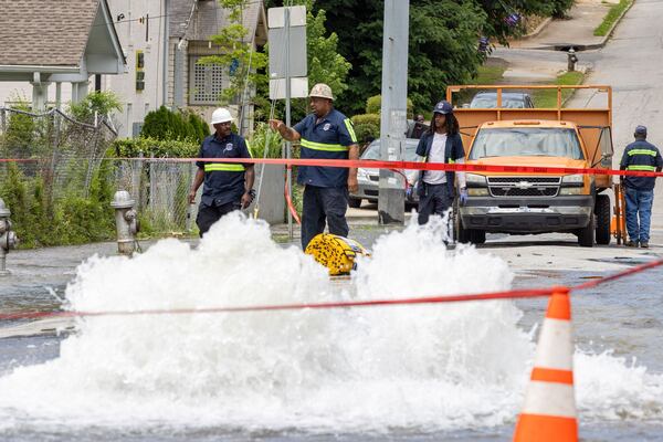 Workers take care of a water main break at Joseph E. Boone Boulevard and James P. Brawley Drive in Atlanta on Friday, May 31, 2024. (Arvin Temkar/AJC 2024)