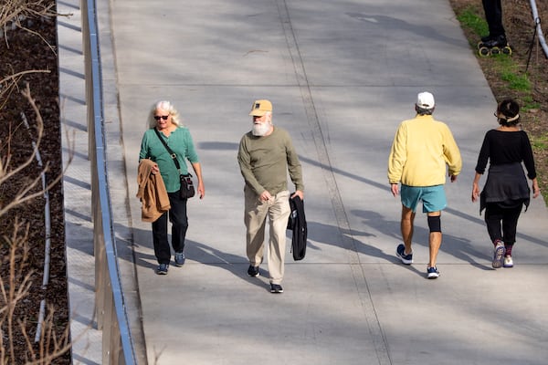 People take off their jackets during a stroll along the Beltline as temperatures climb near 70 degrees on Wednesday, Jan. 7, 2026, in Atlanta. (Ben Hendren for the AJC)