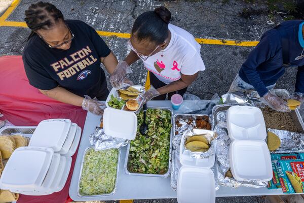 Tasha Thornton (Left) and Pequena Thornton assemble over 100 meals before they hand out tacos during Taco Month in an Atlanta parking lot on Saturday, Sept. 23, 2023.   (Steve Schaefer/steve.schaefer@ajc.com)