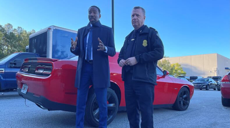 Atlanta police Interim Chief Darin Schierbaum (right) and Mayor Andre Dickens stand in front of an impounded Dodge Challenger on Tuesday morning and warn street racers to stay out of the city or face the consequences.