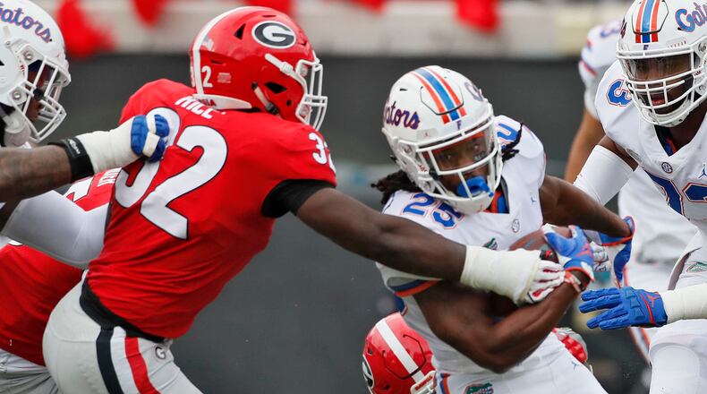 UGA linebacker Monty Rice strips the ball from Gators running back Jordan Scarlett during the team's 2018 matchup in Jacksonville. BOB ANDRES / BANDRES@AJC.COM