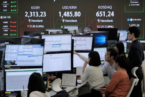 Currency traders watch monitors near a screen showing the Korea Composite Stock Price Index (KOSPI), top left, and the foreign exchange rate between U.S. dollar and South Korean won, top center, at the foreign exchange dealing room of the KEB Hana Bank headquarters in Seoul, South Korea, Wednesday, April 9, 2025. (AP Photo/Ahn Young-joon)
