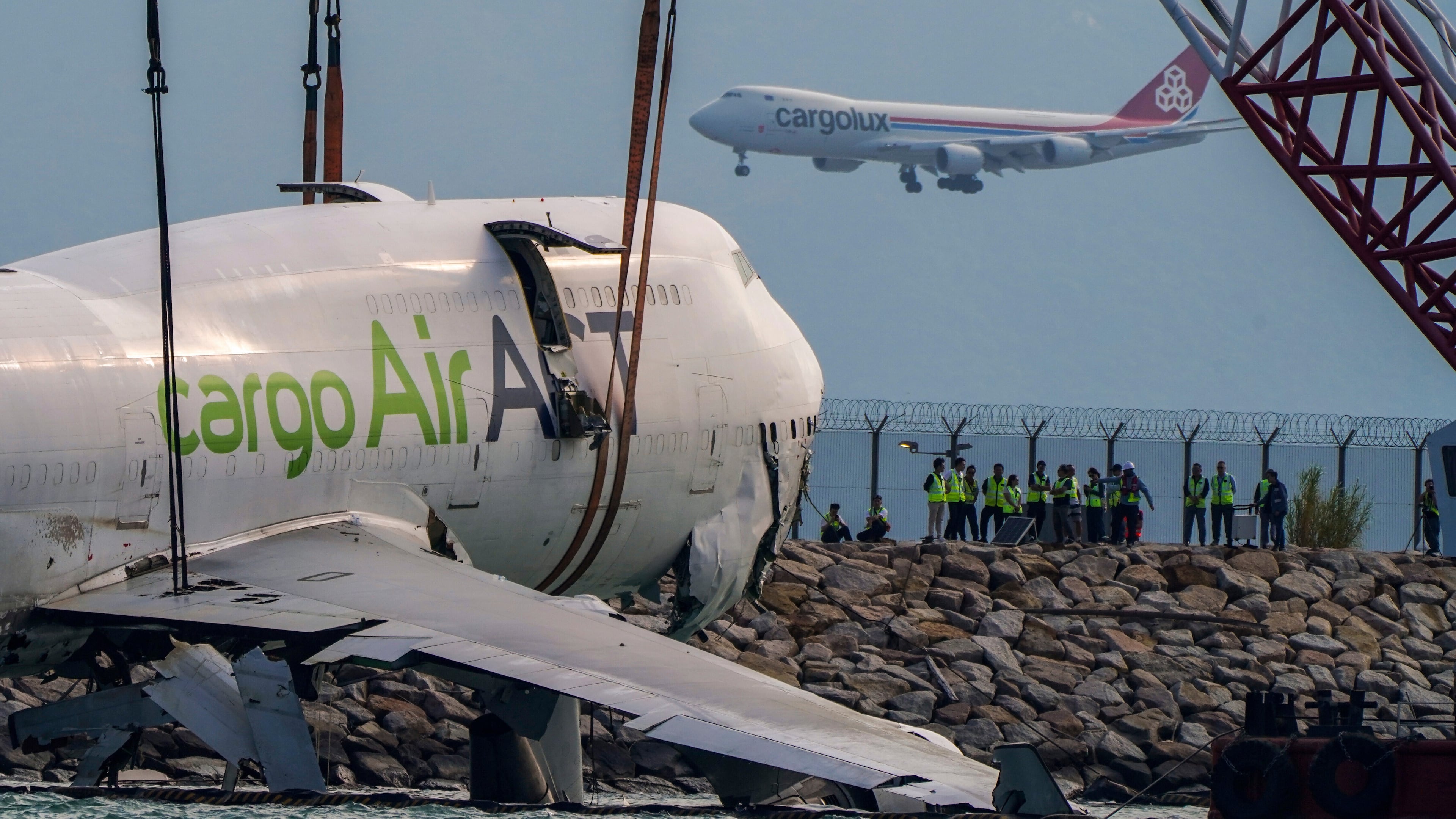 The wreckage of a cargo aircraft that skidded off a runway at the Hong Kong International Airport is prepared for removal on Sunday, Oct. 26, 2025. (AP Photo/Vernon Yuen)