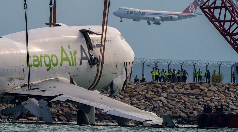 The wreckage of a cargo aircraft that skidded off a runway at the Hong Kong International Airport is prepared for removal on Sunday, Oct. 26, 2025. (AP Photo/Vernon Yuen)