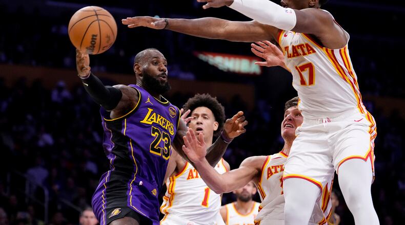 Los Angeles Lakers forward LeBron James, left, passes the ball as Atlanta Hawks forward Jalen Johnson, second from left, guard Bogdan Bogdanovic, second from right, and forward Onyeka Okongwu defend during the first half of an NBA basketball game, Friday, Jan. 3, 2025, in Los Angeles. (Mark J. Terrill/AP)