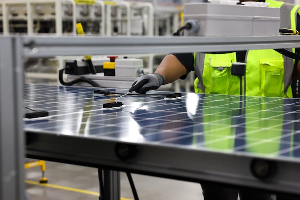Workers inspect panels at the QCells solar factory in White on June 8, 2026. (Arvin Temkar/AJC)